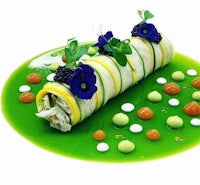 a roll of green food on a white plate