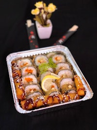 a tray full of sushi on a table with chopsticks