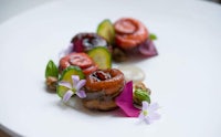 a white plate with vegetables and flowers on it