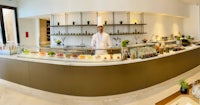 a man standing behind a counter in a restaurant