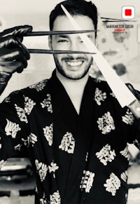 a man in a kimono holding a pair of chopsticks