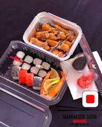 a plastic container with sushi and other food in it