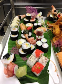 a tray of sushi is on display in a buffet